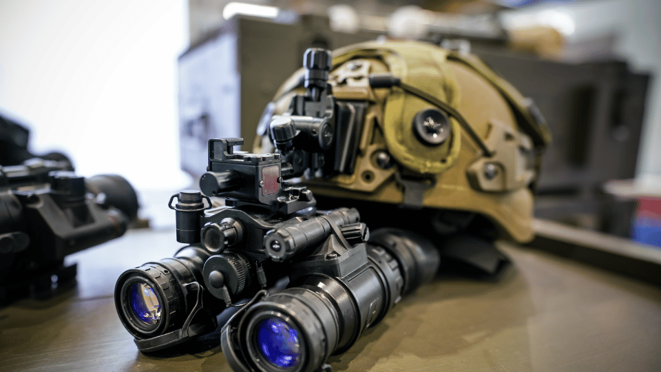 Night vision goggles on military helmet, closeup detail to blue reflective lenses